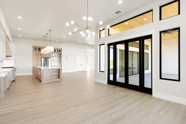 an empty room with ceiling fan and windows