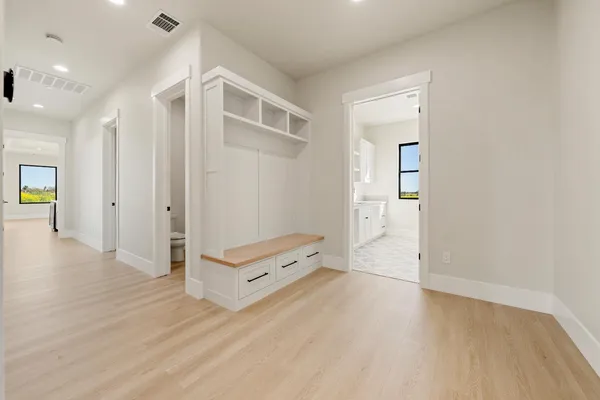 a view of an empty room with a window and a chandelier fan