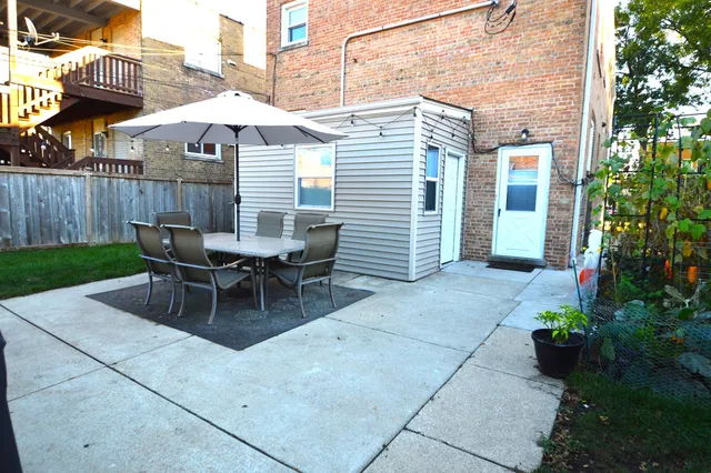 a view of a patio with a table and chairs under an umbrella