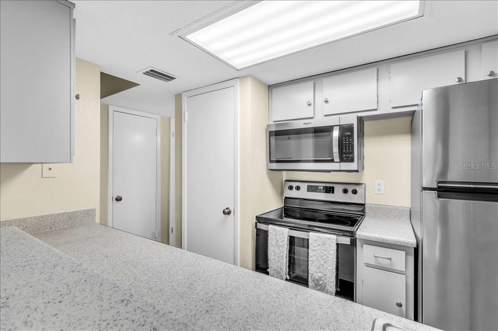 8911 Blind Pass Road, Unit 209 St. Pete Beach, FL 33706 - Photo 14 of 21 a kitchen with a refrigerator stove and microwave