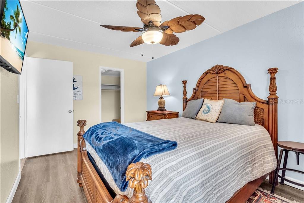 8911 Blind Pass Road, Unit 209 St. Pete Beach, FL 33706 - Photo 15 of 21 a bedroom with a bed and a chandelier