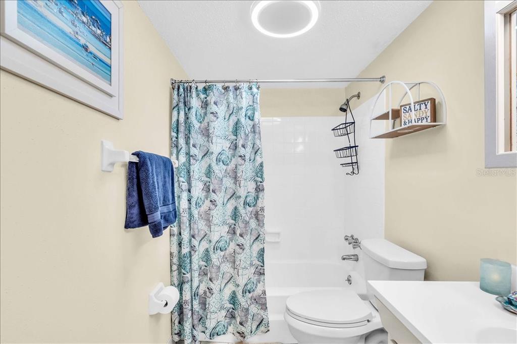 8911 Blind Pass Road, Unit 209 St. Pete Beach, FL 33706 - Photo 16 of 21 a bathroom with a toilet and a shower curtain