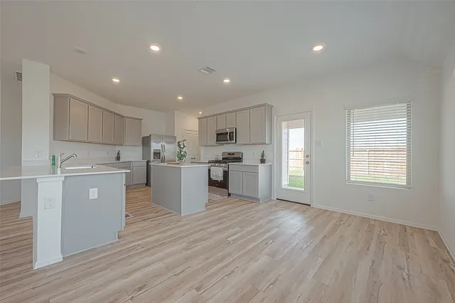 a kitchen with a refrigerator and white cabinets