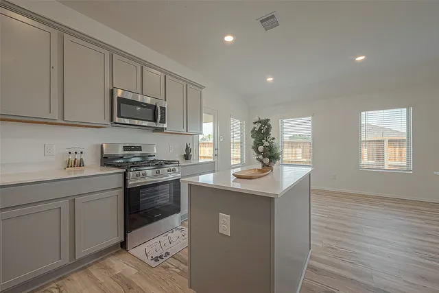 a kitchen with stainless steel appliances granite countertop a sink and stove top oven