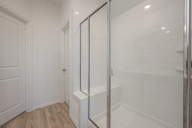 a bathroom with a shower and a glass door