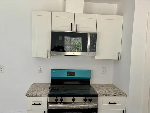 a stove top oven sitting inside of a kitchen