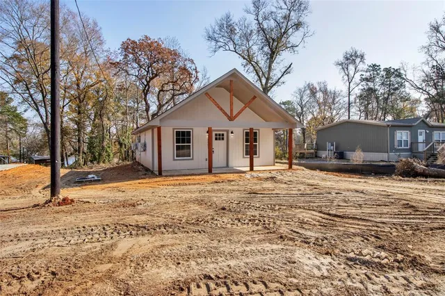 a view of an empty room with wooden floor ceiling fan