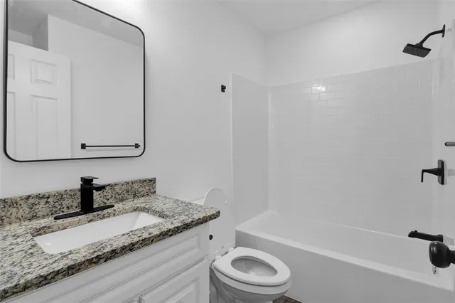 a kitchen with granite countertop a refrigerator stove and sink