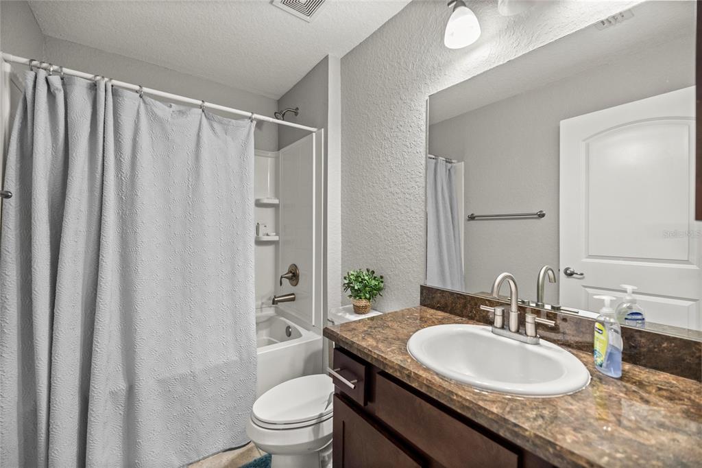 4160 Southwest 100th Street Ocala, FL 34476 - Photo 29 of 42 a bathroom with a granite countertop sink toilet and shower