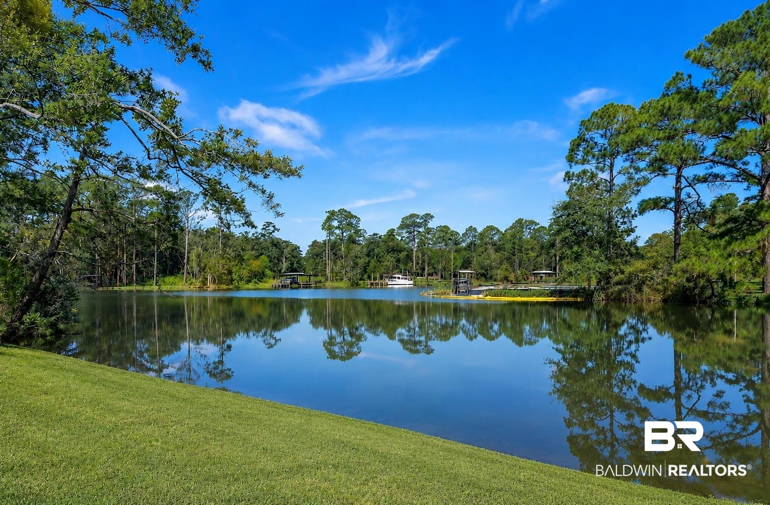 9825 Wolf Creek Ridge Elberta, AL 36530 - Photo 70 of 76 Expansive waterfront property featuring a tranquil lake, lush green lawn, mature trees, a private dock, and a boat slip