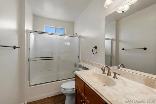 a bathroom with a granite countertop sink toilet and shower