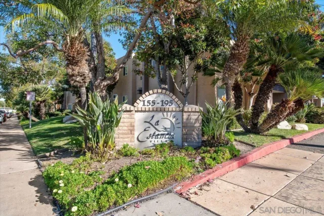 a sign that is sitting in front of a tree