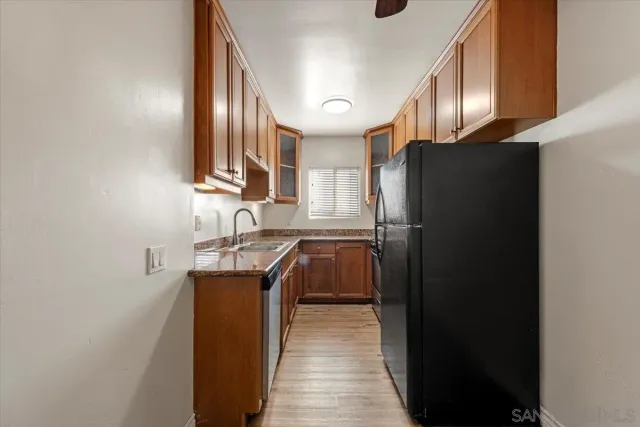 a kitchen with stainless steel appliances granite countertop a refrigerator a sink and a stove