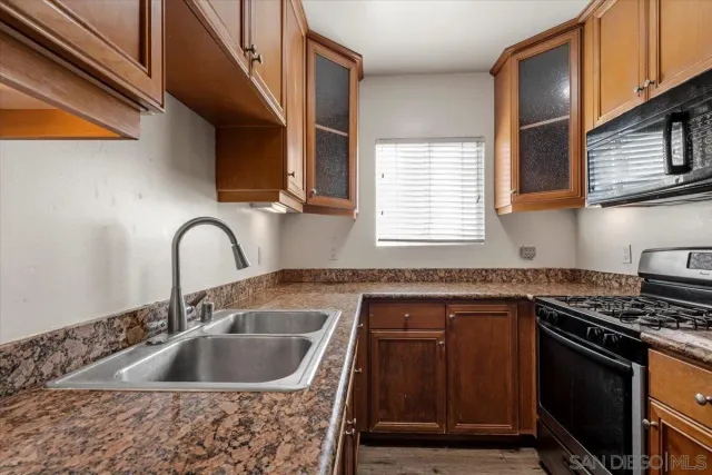 a kitchen with sink a stove and cabinets