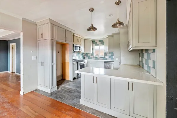 a kitchen with white cabinets and stainless steel appliances
