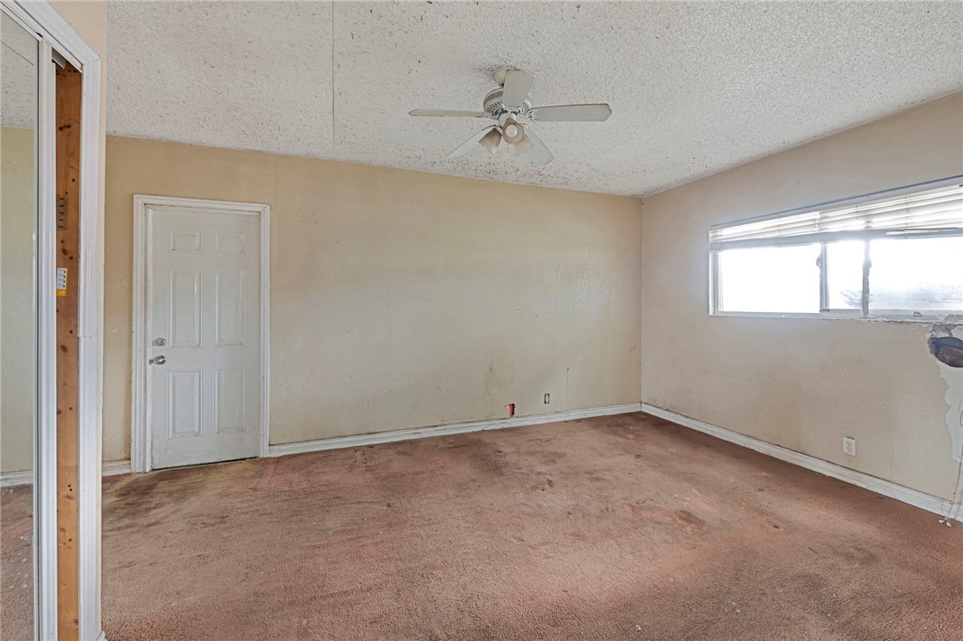 15364 Naranja Avenue Paramount, CA 90723 - Photo 20 of 28 an empty room with a ceiling fan and windows