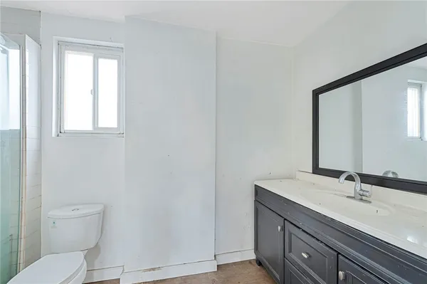 a bathroom with a toilet a sink and mirror
