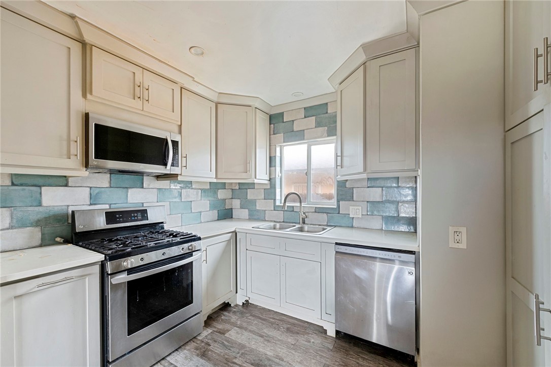 15364 Naranja Avenue Paramount, CA 90723 - Photo 9 of 28 a kitchen with white cabinets stainless steel appliances and sink