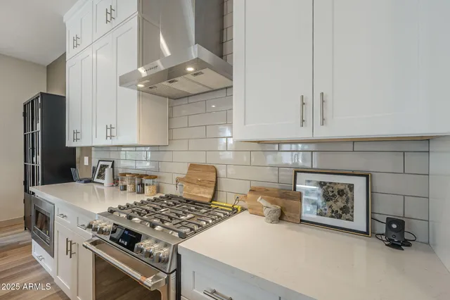 a kitchen with granite countertop a stove a sink and a refrigerator