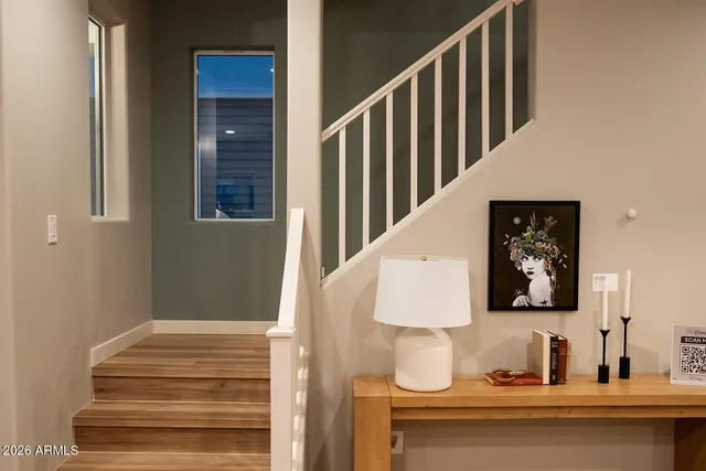 a living room with lots of furniture kitchen view and a chandelier