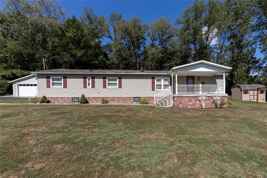 a front view of a house with a yard and trees