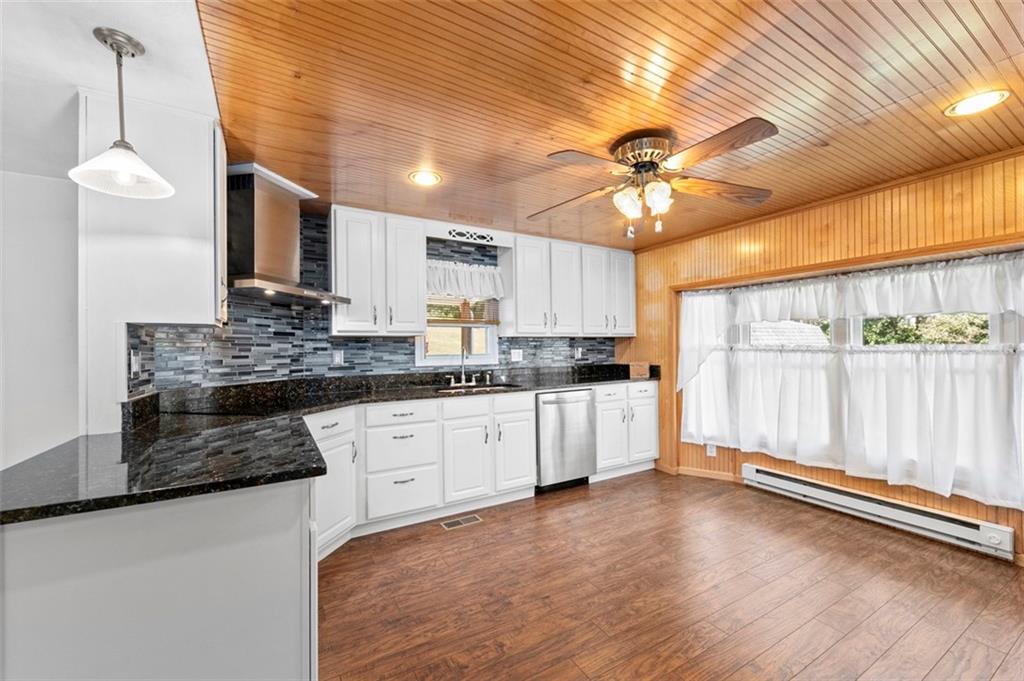 1017 Nellie Road Vanderbilt, PA 15486 - Photo 14 of 31 a kitchen with a stove a sink and white cabinets with wooden floor