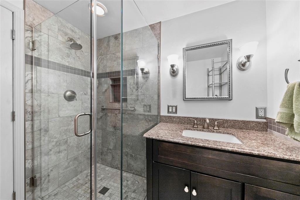 1017 Nellie Road Vanderbilt, PA 15486 - Photo 26 of 31 a bathroom with a granite countertop sink a mirror and shower