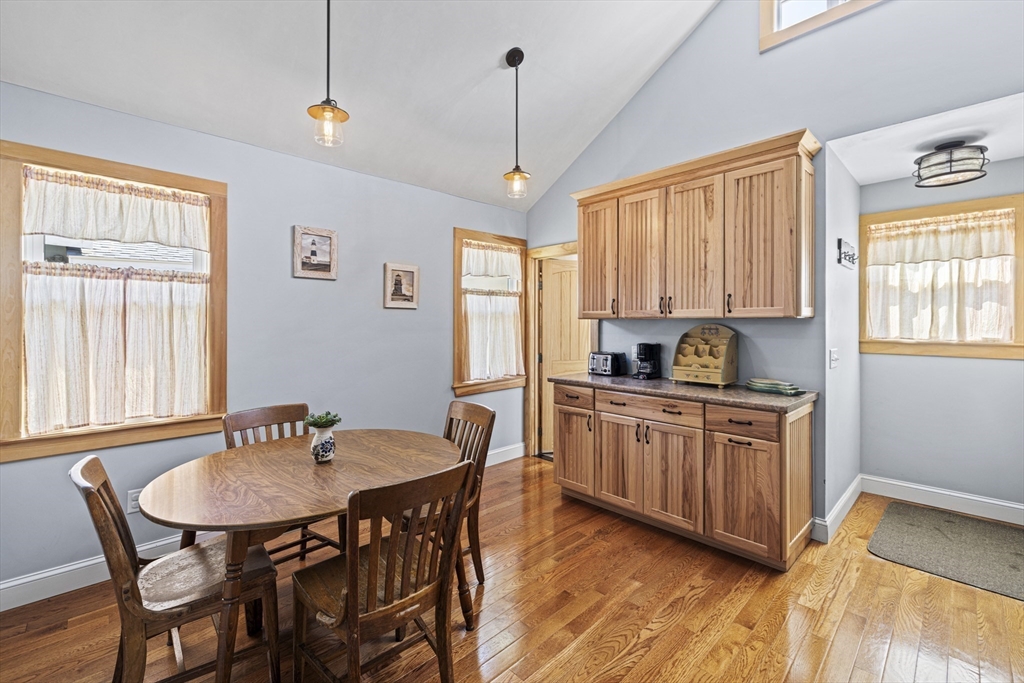 5 Meade Street Wareham, MA 02571 - Photo 9 of 21 a kitchen with stainless steel appliances granite countertop a dining table chairs a sink and dishwasher a refrigerator with wooden floor