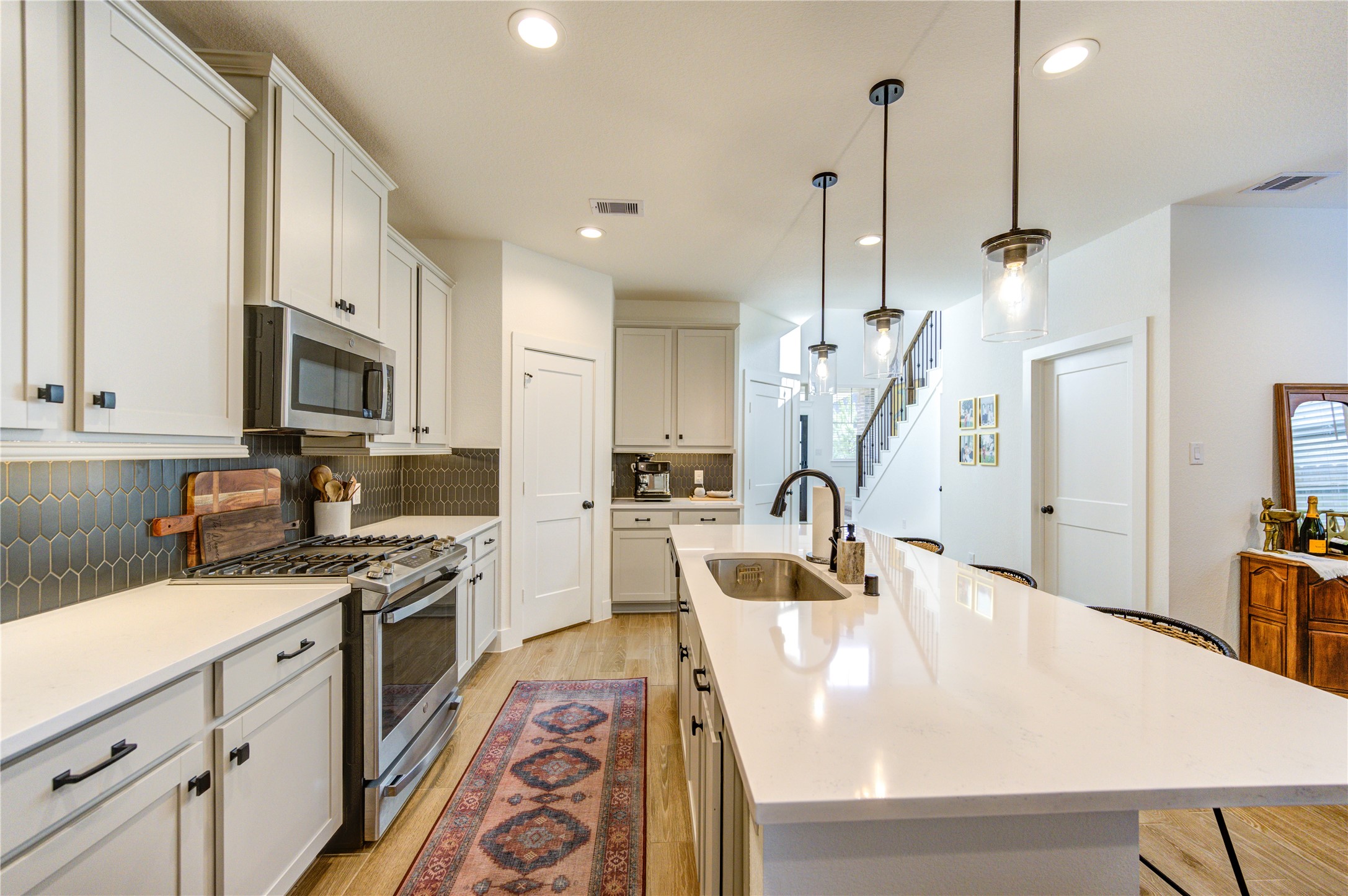 17758 Tree Of Heaven Conroe, TX 77385 - Photo 12 of 44 a kitchen with stainless steel appliances granite countertop a sink a stove and a wooden floors