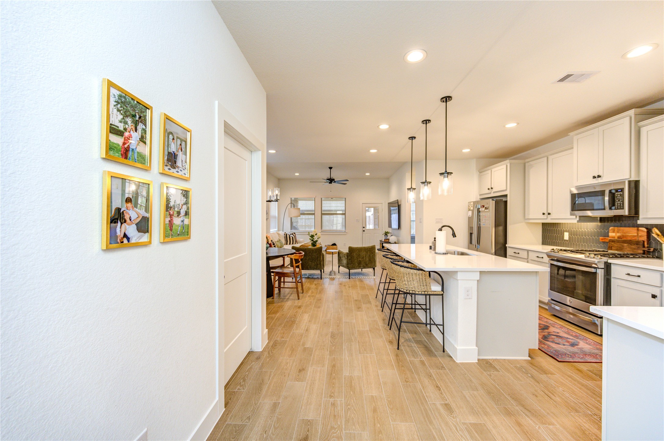 17758 Tree Of Heaven Conroe, TX 77385 - Photo 16 of 44 a living room with stainless steel appliances kitchen island granite countertop furniture wooden floor and a view of kitchen