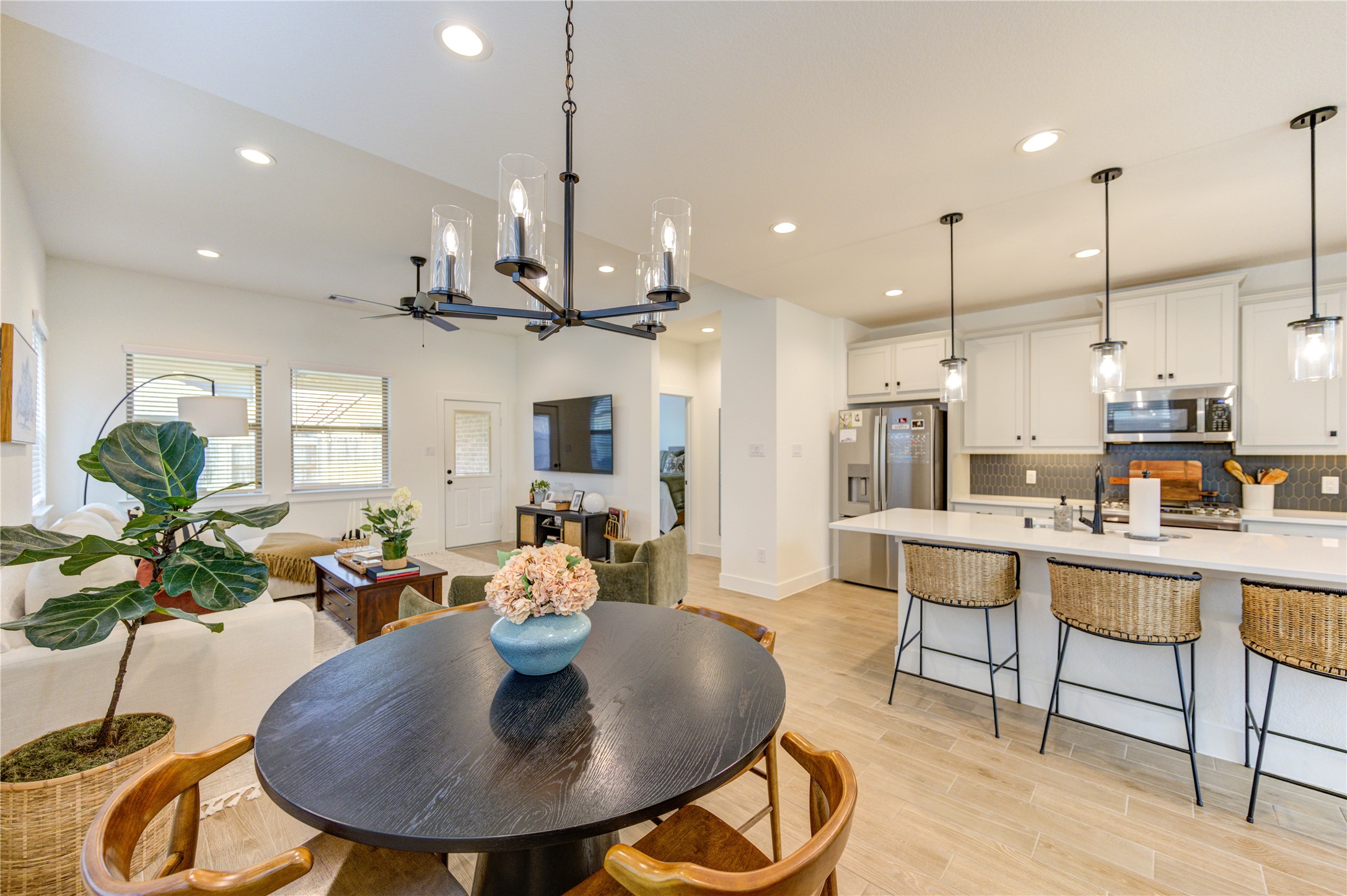 17758 Tree Of Heaven Conroe, TX 77385 - Photo 10 of 44 a kitchen with stainless steel appliances kitchen island granite countertop a table chairs and a living room view