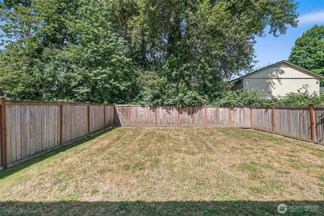 a view of backyard with wooden fence