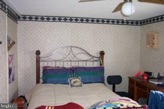 27506 Waller Road Hebron, MD 21830 - Photo 2 of 6 a bedroom with a bed and a chandelier