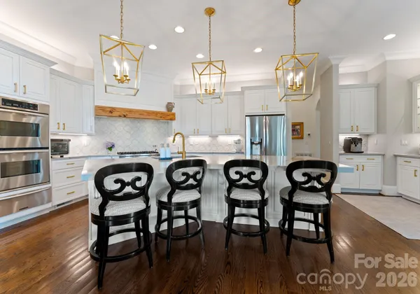 a kitchen with stainless steel appliances a table chairs and wooden floor