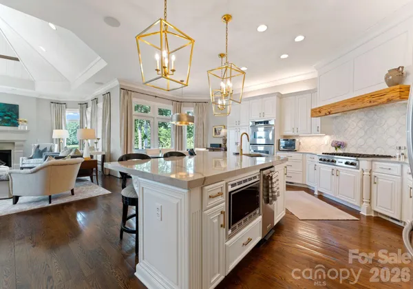 a kitchen with stainless steel appliances granite countertop a sink a stove and a wooden floors