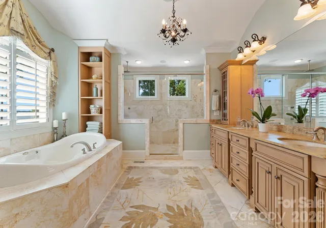a spacious bathroom with a double vanity sink a large mirror and a bathtub