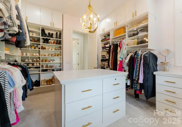 a view of walk in closet with clothes and shoes