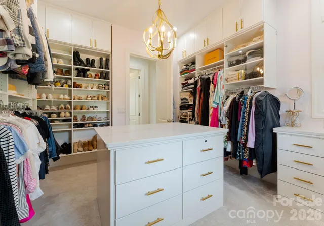 a view of walk in closet with clothes and shoes