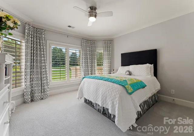 a bed sitting in a spacious bedroom next to a window