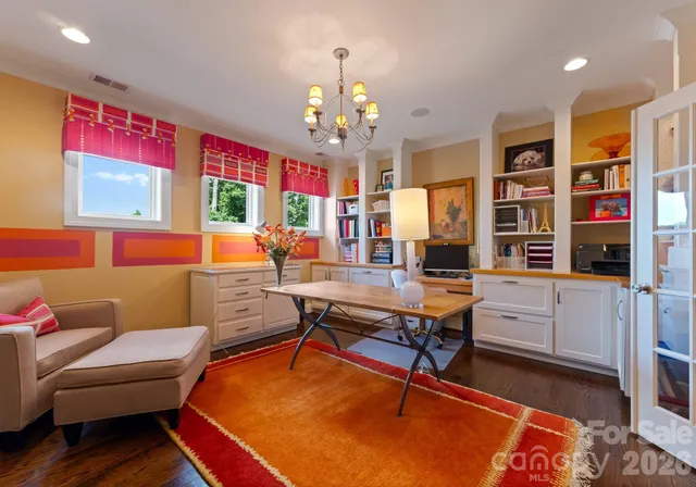 a living room with furniture a chandelier and a bookshelf
