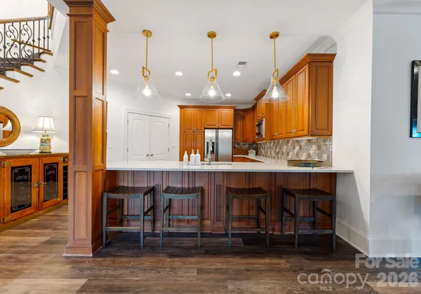 a kitchen with kitchen island granite countertop a table chairs sink and cabinets