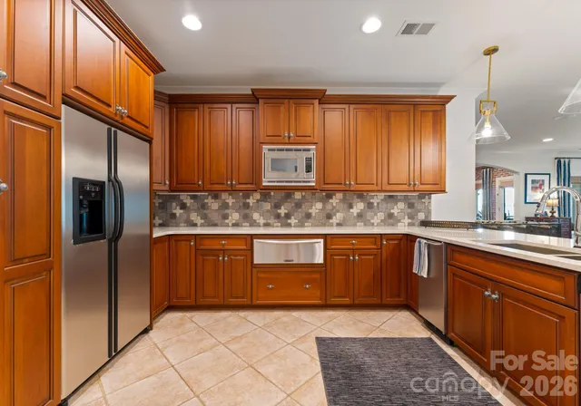 a kitchen with stainless steel appliances granite countertop a refrigerator and wooden cabinets