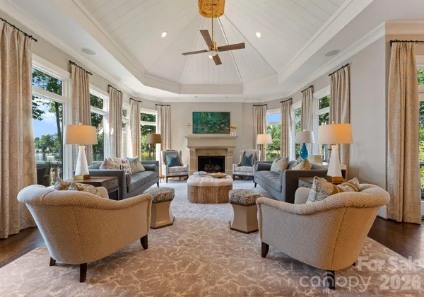 a living room with furniture fireplace and a large window