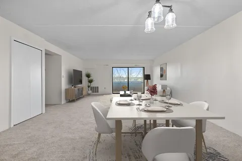 a view of a dining room with furniture a chandelier and wooden floor