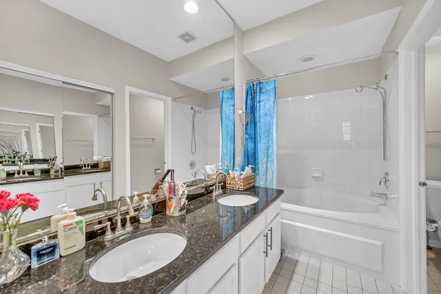 a bathroom with a granite countertop sink mirror and a bathtub