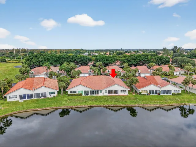 an aerial view of a house with a garden and lake view