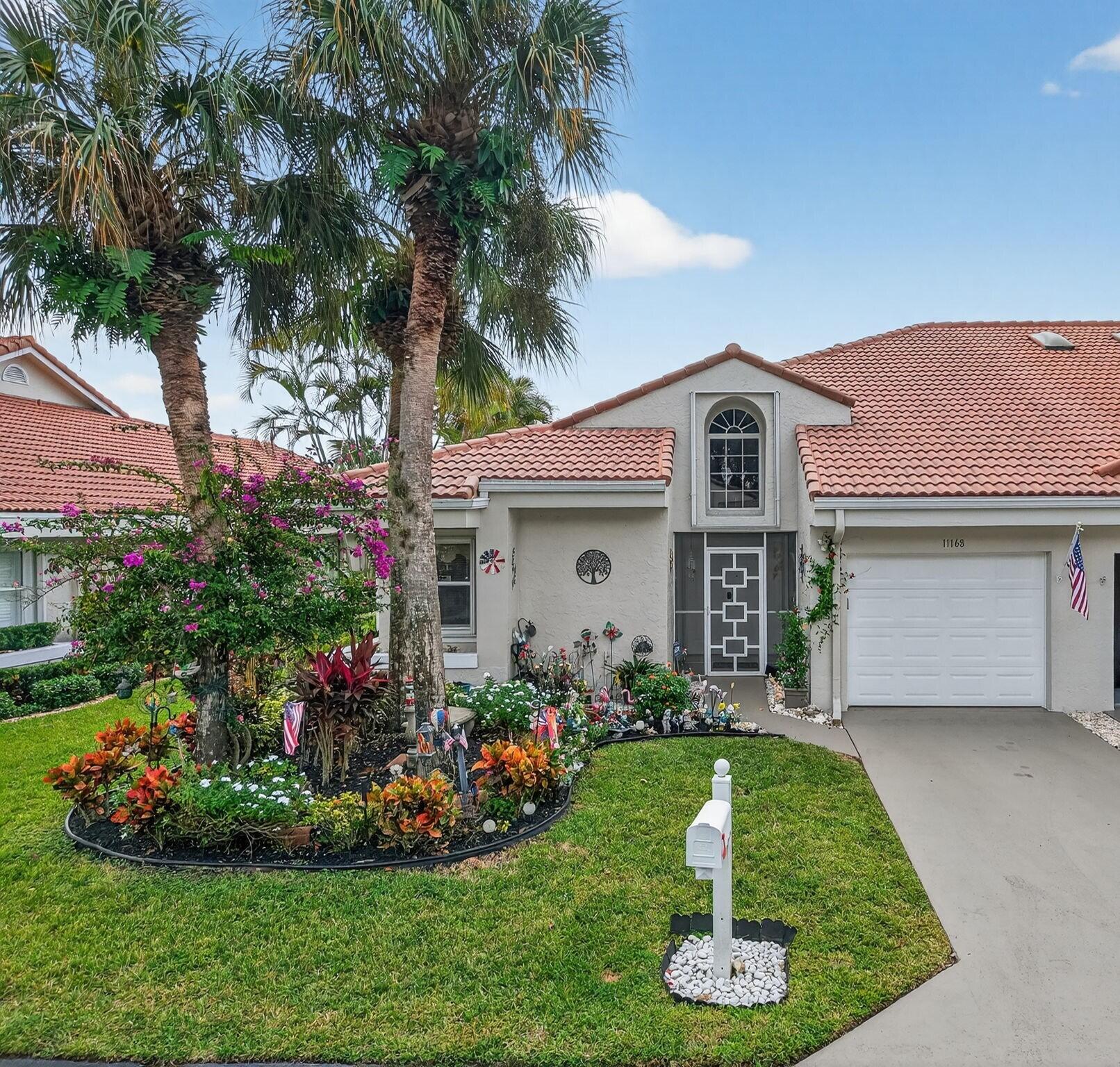 11168 Sangria Court Boca Raton, FL 33498 - Photo 41 of 63 a front view of a house with a garden and plants