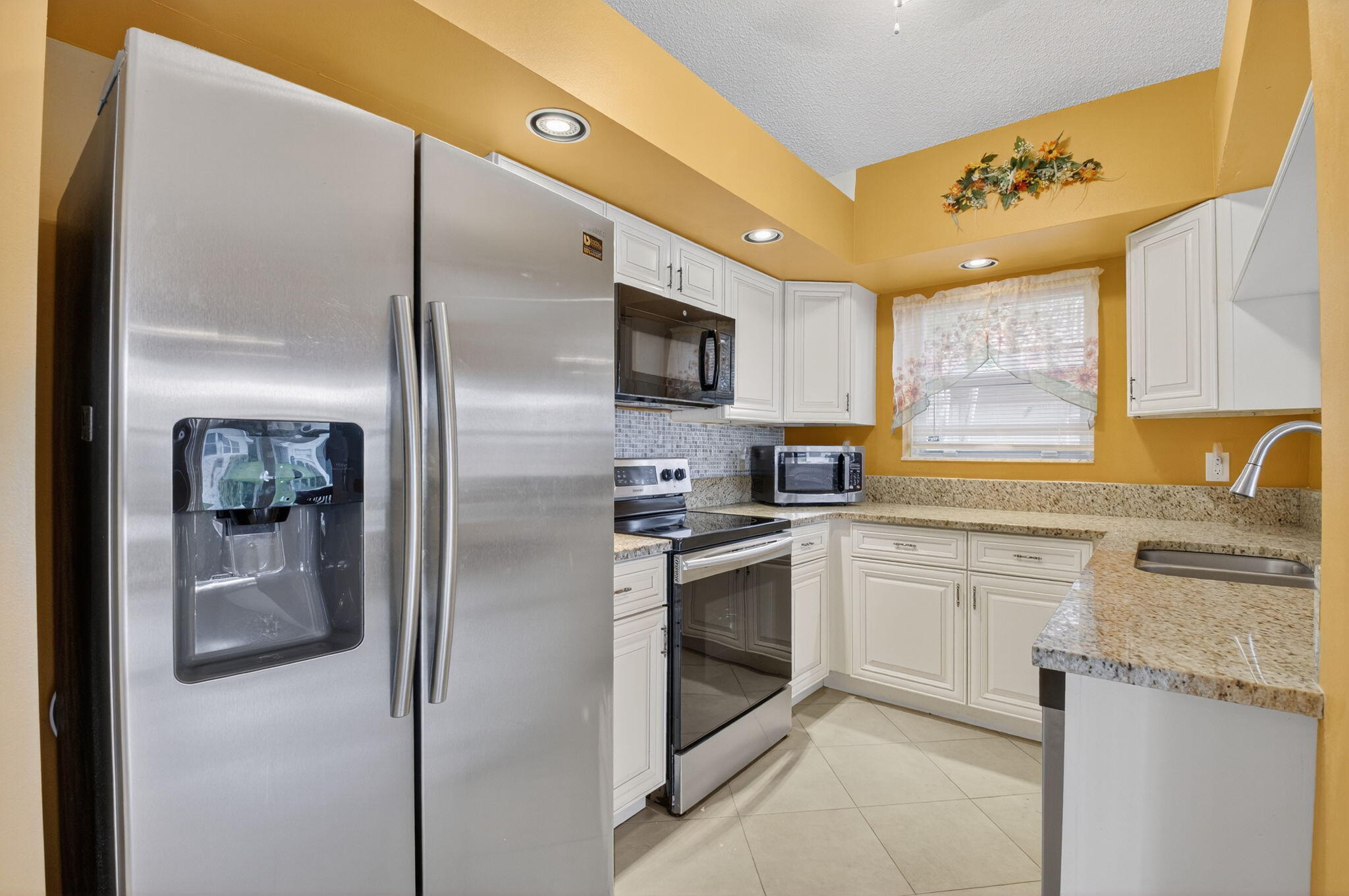 11168 Sangria Court Boca Raton, FL 33498 - Photo 8 of 63 a kitchen with stainless steel appliances granite countertop a refrigerator a stove a sink and a microwave