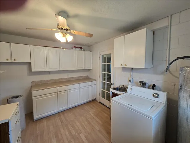 a kitchen with cabinets a washer and dryer