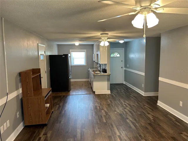 a view of a refrigerator in kitchen and dining room with wooden floor